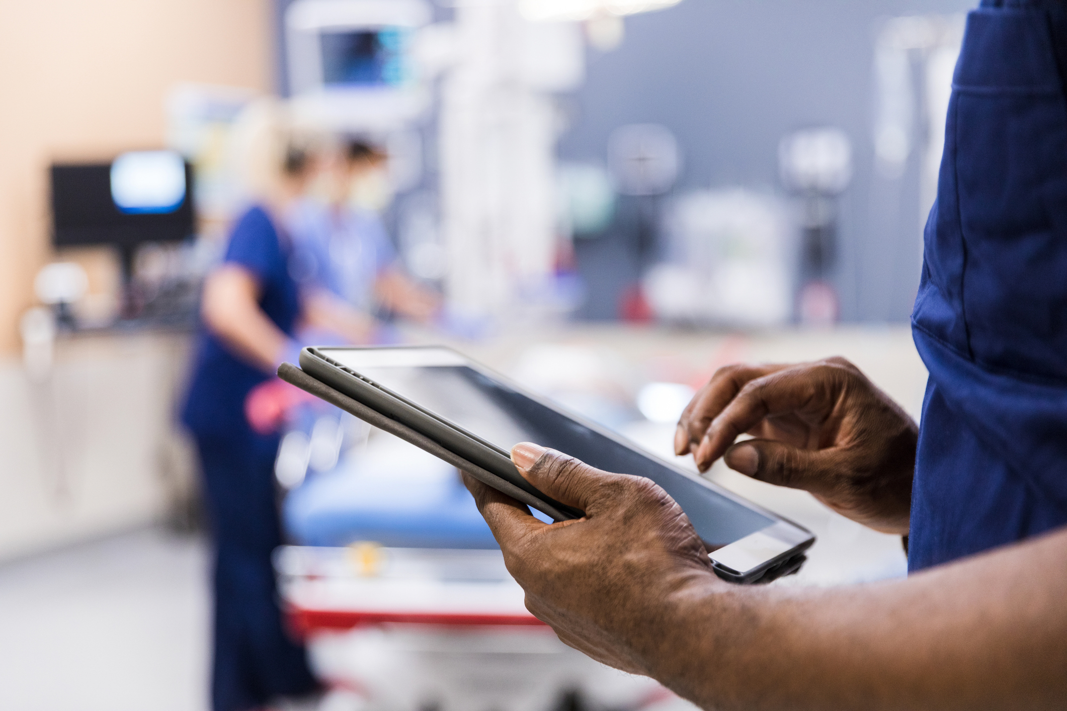 The unrecognizeable medical staff uses digital tablet to review medical chart.
